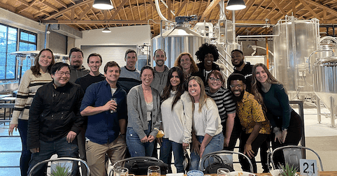 group of people in office listening to a speaker during a meeting